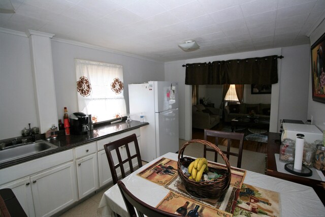 72 Brooker St, Torrington, CT 06790 - kitchen featuring freestanding refrigerator, crown molding, a sink, dark countertops, and white cabinets