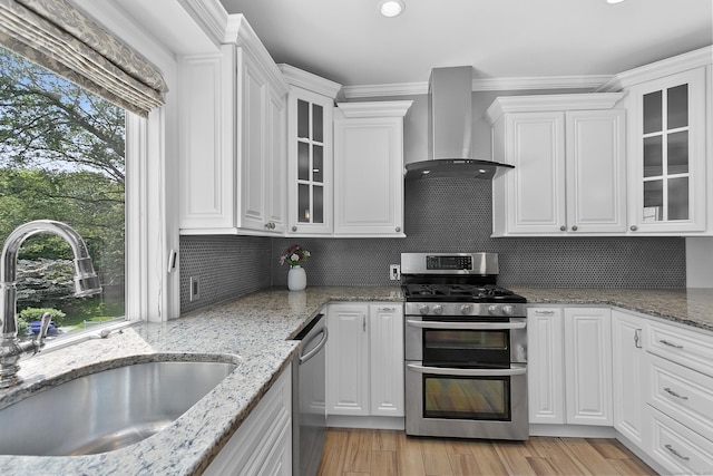 42 Woodledge Rd, Stamford, CT 06907 - kitchen with appliances with stainless steel finishes, wall chimney range hood, and white cabinetry