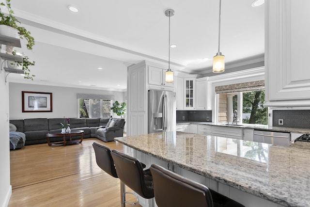 42 Woodledge Rd, Stamford, CT 06907 - kitchen with stainless steel appliances, a kitchen breakfast bar, light stone counters, tasteful backsplash, and recessed lighting