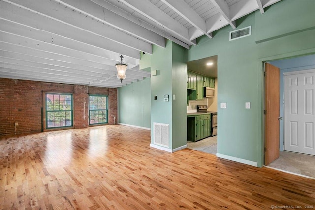 1 Front St Unit 204, New Haven, CT 06513 - unfurnished living room with light wood finished floors, brick wall, beamed ceiling, and baseboards