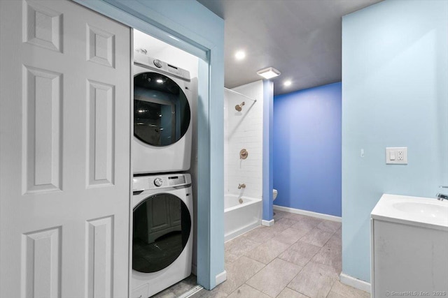 1 Front St Unit 204, New Haven, CT 06513 - washroom with estacked washer and dryer, baseboards, light tile patterned floors, and recessed lighting