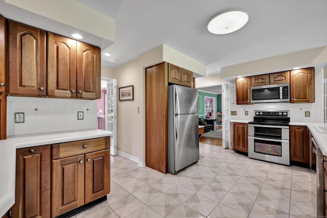 87 Falcon Crest Rd, Middlebury, CT 06762 - kitchen with stainless steel appliances, tasteful backsplash, light countertops, brown cabinetry, and recessed lighting