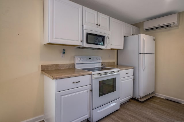 36 State St, Guilford, CT 06437 - kitchen featuring white appliances, a wall mounted AC, white cabinets, and light wood-type flooring