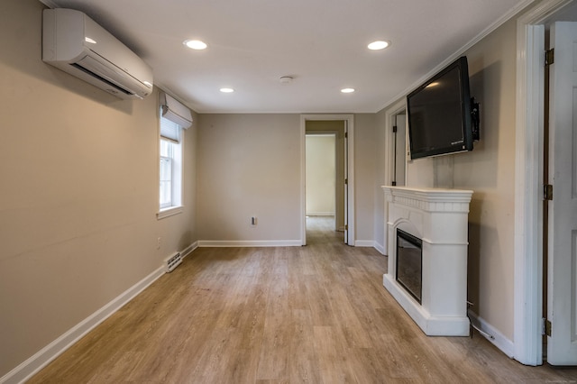 36 State St, Guilford, CT 06437 - unfurnished living room featuring an AC wall unit, light wood-style flooring, baseboards, a glass covered fireplace, and recessed lighting