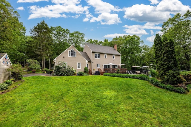 3580 Phelps Rd, Suffield, CT 06093 - rear view of property featuring a chimney, a lawn, and a deck