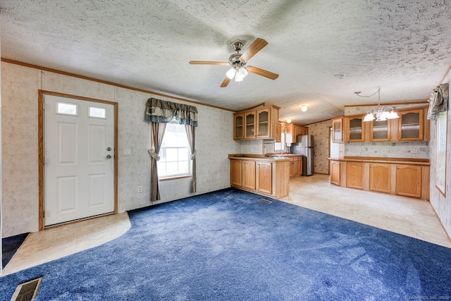 107 Lions Way, Windham, CT 06256 - kitchen with freestanding refrigerator, brown cabinets, a peninsula, glass insert cabinets, and vaulted ceiling