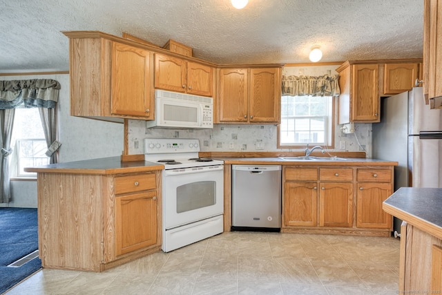 107 Lions Way, Windham, CT 06256 - kitchen featuring stainless steel appliances, a sink, a textured ceiling, and brown cabinets
