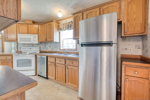 107 Lions Way, Windham, CT 06256 - kitchen with appliances with stainless steel finishes, a sink, a textured ceiling, and brown cabinets