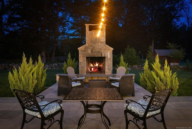 300 Hollow Tree Ridge Rd, Darien, CT 06820 - patio at night with an outdoor stone fireplace and a patio area