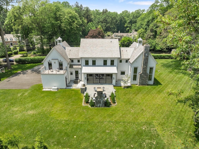 300 Hollow Tree Ridge Rd, Darien, CT 06820 - back of property with a standing seam roof, a chimney, a lawn, and metal roof