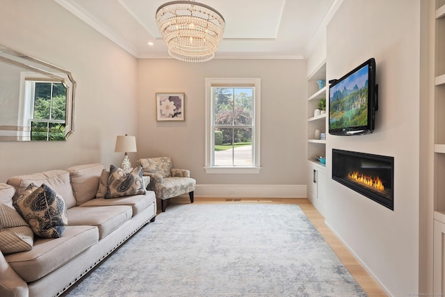 300 Hollow Tree Ridge Rd, Darien, CT 06820 - living room featuring a chandelier, light wood-type flooring, a glass covered fireplace, built in features, and crown molding