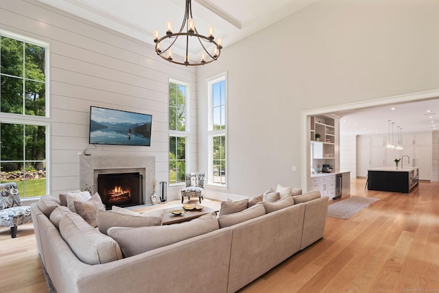 300 Hollow Tree Ridge Rd, Darien, CT 06820 - living area with a chandelier, healthy amount of natural light, light wood finished floors, a premium fireplace, and a high ceiling