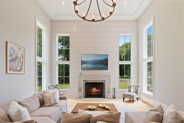 300 Hollow Tree Ridge Rd, Darien, CT 06820 - living room featuring wood finished floors, a warm lit fireplace, plenty of natural light, and a chandelier