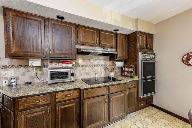 34 Cedar Rock Rd, Woodbridge, CT 06525 - kitchen with under cabinet range hood, double wall oven, black electric stovetop, baseboards, and decorative backsplash