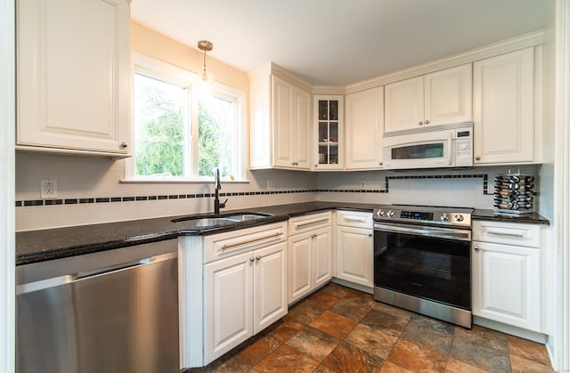 227 Thistle Ln, Southington, CT 06489 - kitchen with appliances with stainless steel finishes, a sink, stone finish flooring, decorative backsplash, and glass insert cabinets