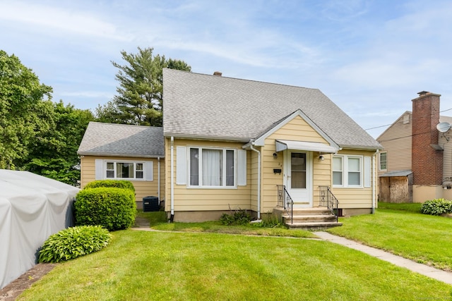 24 Goff St, Waterbury, CT 06704 - view of front of property with a front lawn, a shingled roof, and central AC unit