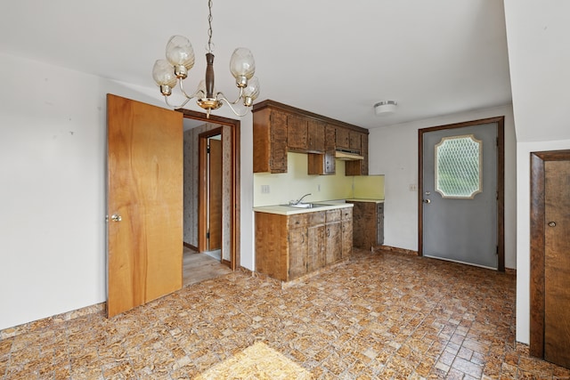 24 Goff St, Waterbury, CT 06704 - kitchen with under cabinet range hood, light countertops, a chandelier, a sink, and hanging light fixtures