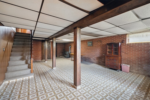 24 Goff St, Waterbury, CT 06704 - below grade area with a paneled ceiling, brick wall, stairway, and a wood stove