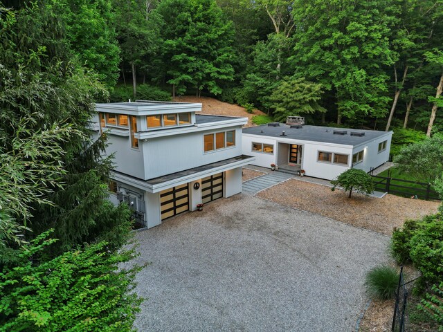 99 High Ridge Rd, Pound Ridge, NY 10576 - modern home with driveway, a garage, and a view of trees