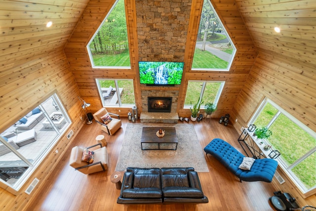 732 Hulls Hill Rd, Southbury, CT 06488 - living room with high vaulted ceiling, a fireplace, hardwood / wood-style flooring, and wooden walls