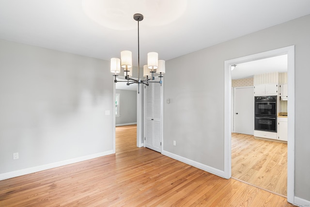 33 Deer Park Rd, Simsbury, CT 06089 - unfurnished room featuring a chandelier, light wood-type flooring, and baseboards