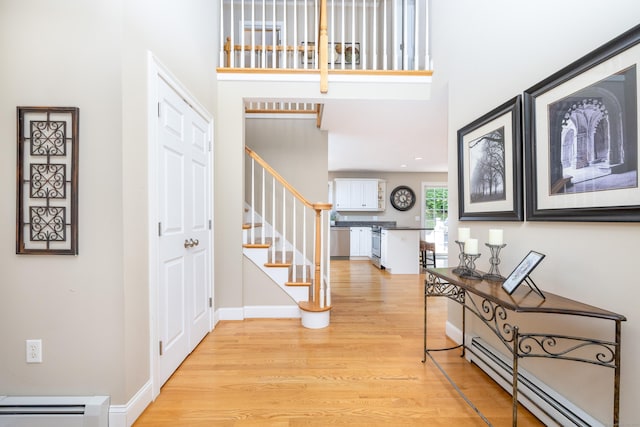 1382 Cedar Swamp Rd, Coventry, CT 06238 - foyer entrance featuring a baseboard radiator, a baseboard heating unit, light wood-style floors, stairway, and a towering ceiling