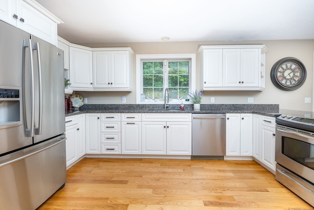 1382 Cedar Swamp Rd, Coventry, CT 06238 - kitchen with appliances with stainless steel finishes, a sink, white cabinets, dark stone countertops, and light wood-style flooring