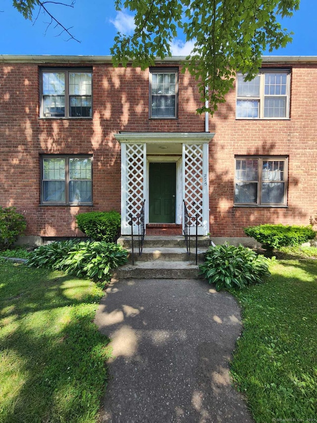275 Texas Ave Unit D, Bridgeport, CT 06610 - view of front facade with brick siding and a front lawn