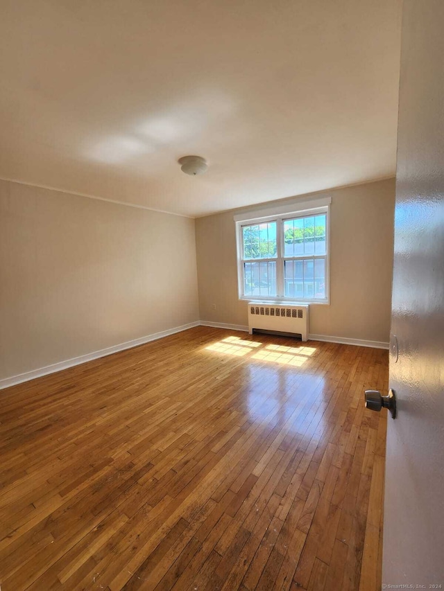 275 Texas Ave Unit D, Bridgeport, CT 06610 - unfurnished room featuring radiator heating unit, wood-type flooring, and baseboards