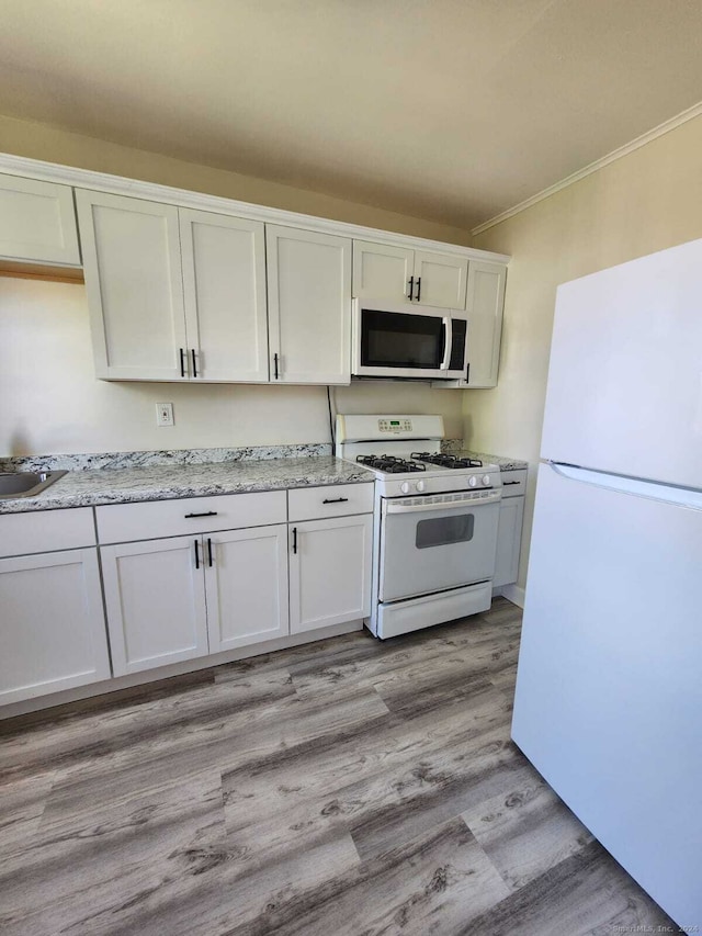 275 Texas Ave Unit D, Bridgeport, CT 06610 - kitchen with white appliances, ornamental molding, light wood-type flooring, light stone countertops, and white cabinets