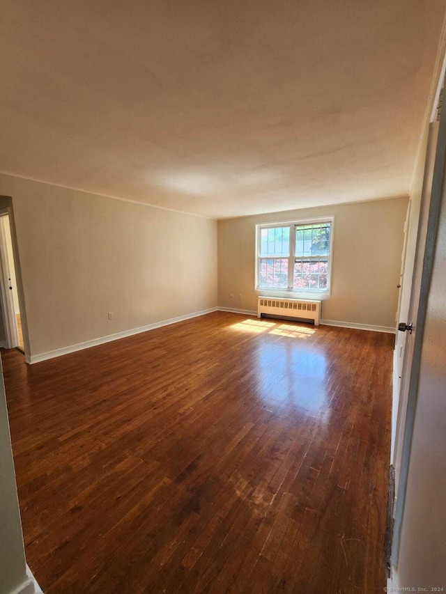 275 Texas Ave Unit D, Bridgeport, CT 06610 - empty room with radiator heating unit, dark wood-style flooring, and baseboards
