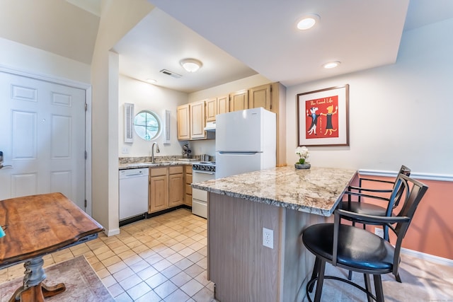 923 Old Pond Ln Unit 923, Norwich, CT 06360 - kitchen with white appliances, light brown cabinetry, a breakfast bar area, a sink, and recessed lighting