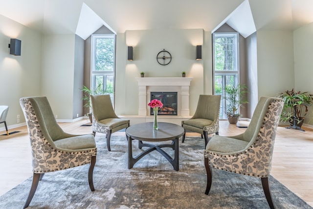923 Old Pond Ln Unit 923, Norwich, CT 06360 - sitting room with wood finished floors, vaulted ceiling, healthy amount of natural light, a glass covered fireplace, and baseboards