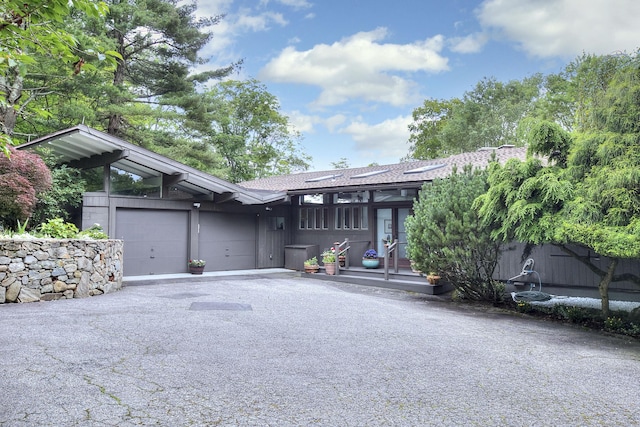 62 Wells Hill Rd, Weston, CT 06883 - view of front facade with asphalt driveway, an attached garage, a wooden deck, a shingled roof, and french doors