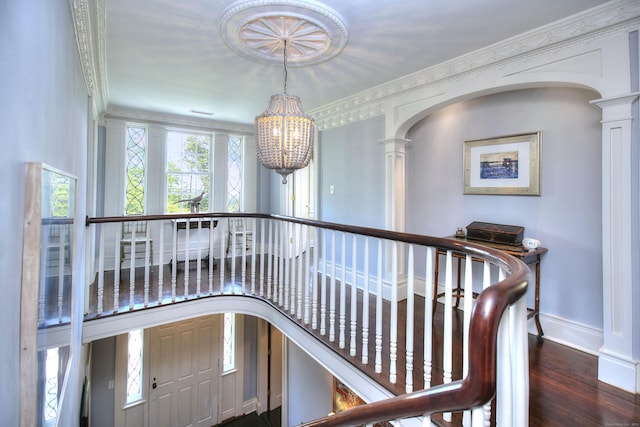 2683 Bronson Rd, Fairfield, CT 06824 - hall with decorative columns, a chandelier, arched walkways, wood finished floors, and ornamental molding
