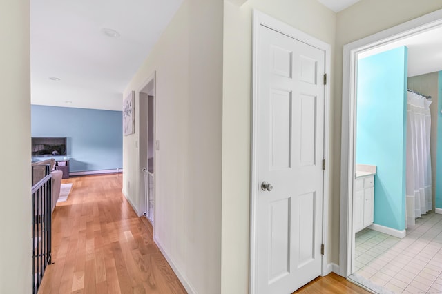 175 Cross Hill Rd, Monroe, CT 06468 - corridor featuring baseboards, light wood-style floors, and a baseboard radiator