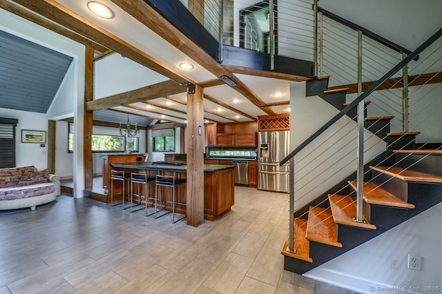 94 Boston Post Rd, Madison, CT 06443 - kitchen with appliances with stainless steel finishes, dark countertops, brown cabinets, open floor plan, and light wood-type flooring