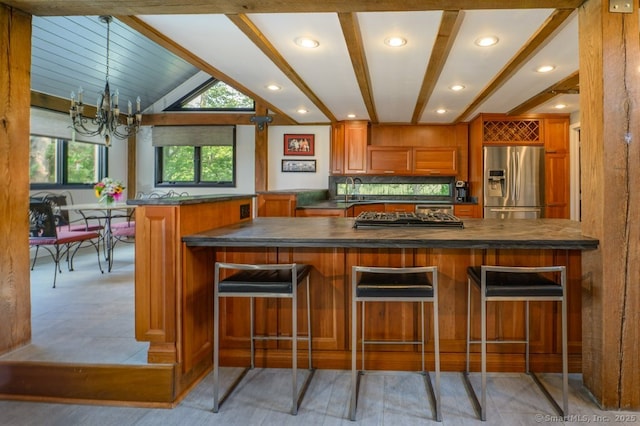 94 Boston Post Rd, Madison, CT 06443 - kitchen featuring stainless steel fridge, dark countertops, brown cabinets, a chandelier, and a breakfast bar area