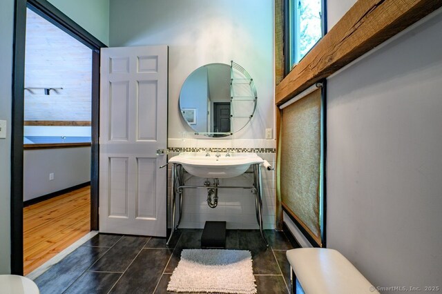 94 Boston Post Rd, Madison, CT 06443 - bathroom with tile patterned floors, toilet, a sink, and tile walls