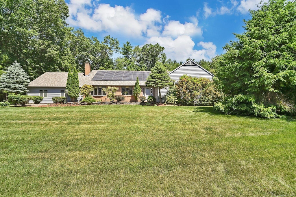 55 Windshire Dr, South Windsor, CT 06074 - ranch-style home featuring solar panels, a chimney, a front yard, and a shingled roof