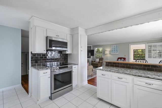 290 Neck Rd, Madison, CT 06443 - kitchen featuring stainless steel appliances, light tile patterned floors, white cabinetry, and decorative backsplash