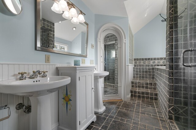 290 Neck Rd, Madison, CT 06443 - full bathroom with a stall shower, vaulted ceiling, wainscoting, stone finish flooring, and a sink