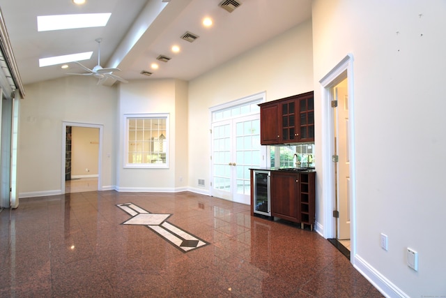 11 Pheasant Ridge Rd, Newtown, CT 06470 - unfurnished living room with wine cooler, granite tiled floors, a skylight, ceiling fan, and high vaulted ceiling