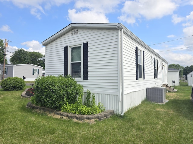 57 Cheyenne Rd, East Hartford, CT 06118 - view of side of home with a central AC unit and a lawn