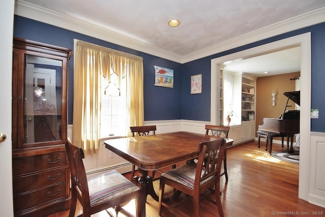 2 Tamshell Dr, Kent, CT 06757 - dining space with baseboard heating, wood finished floors, a wainscoted wall, crown molding, and a decorative wall