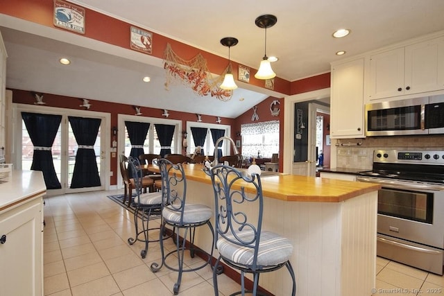 2 Tamshell Dr, Kent, CT 06757 - kitchen featuring appliances with stainless steel finishes, butcher block counters, light tile patterned floors, a kitchen breakfast bar, and white cabinetry