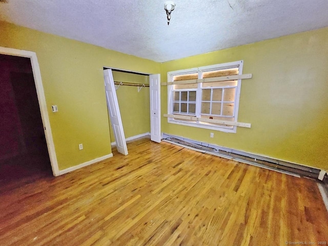 270 Capen St, Hartford, CT 06112 - unfurnished bedroom featuring wood finished floors, a closet, baseboards, baseboard heating, and a textured ceiling