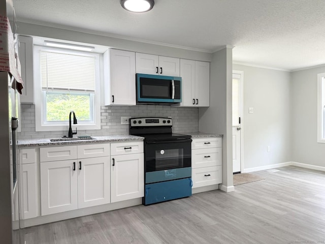 40 Cherry St, Hartford, CT 06106 - kitchen with electric range, decorative backsplash, light wood finished floors, a textured ceiling, and white cabinetry