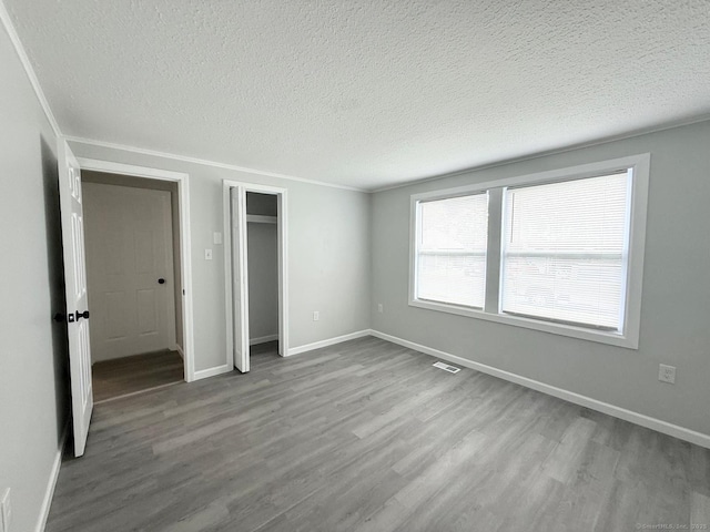 40 Cherry St, Hartford, CT 06106 - unfurnished bedroom with wood finished floors, a textured ceiling, a closet, and ornamental molding
