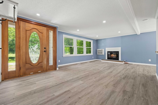 157 Mile Creek Rd, Old Lyme, CT 06371 - entrance foyer featuring a wall mounted AC, wood finished floors, a textured ceiling, a glass covered fireplace, and crown molding